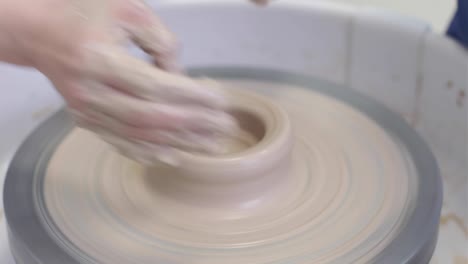 video women's hands make a plate of clay on a potter's wheel.