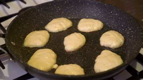 the cook is frying pancakes on the home stove, timelapse