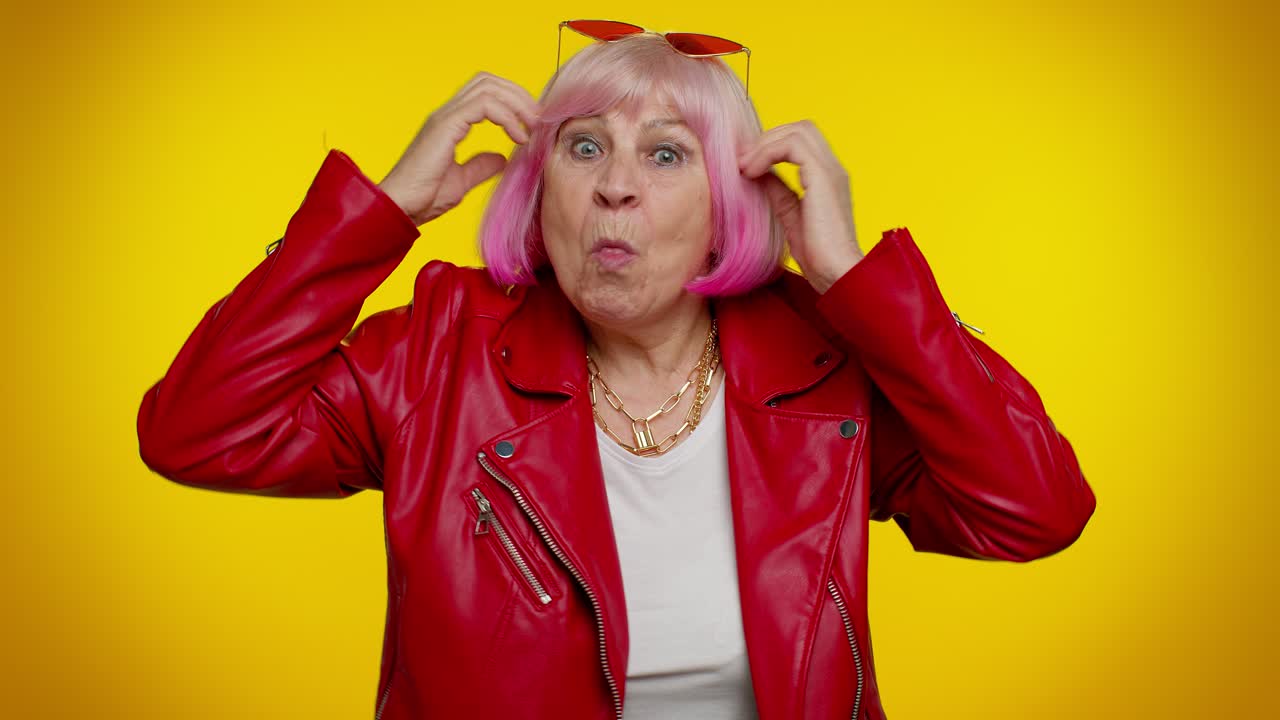 mujer mayor elegante con cabello rosa y chaqueta roja