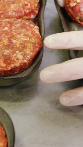 la mano del carnicero empaquetando la carne horneada en un recipiente