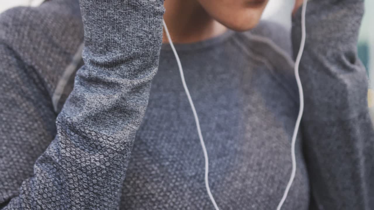 Young woman listening to music before running