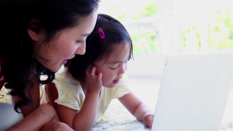 mother using a laptop with her daughter