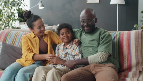 portrait of joyous african american family on sofa at home