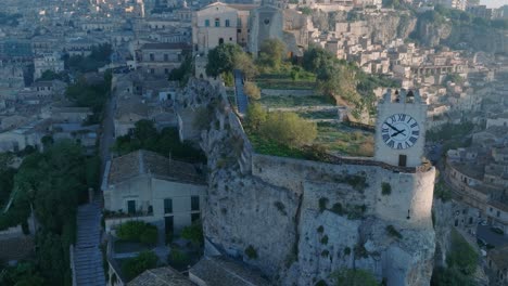 Aerial-view-of-Modica-Alta-Val-di-Noto-Sicily-Old-Baroque-Town-and-Castle-Clock-Tower-South-Italy-at-Sunrise