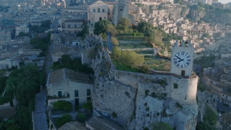 aerial view of modica alta val di noto sicily old baroque town and castle clock tower south italy at sunrise