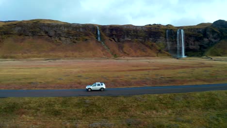 tiro de seguimiento siga el coche que pasa por la cascada de skogafoss, paisaje islandés, antena