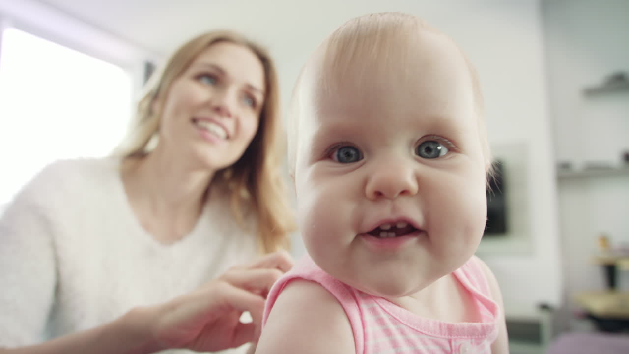 어린 엄마 가 아이 를 입히고 있다. 엄마 와 아이 가 산책 을 하고 있다