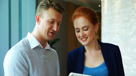 executives discussing over digital tablet in office