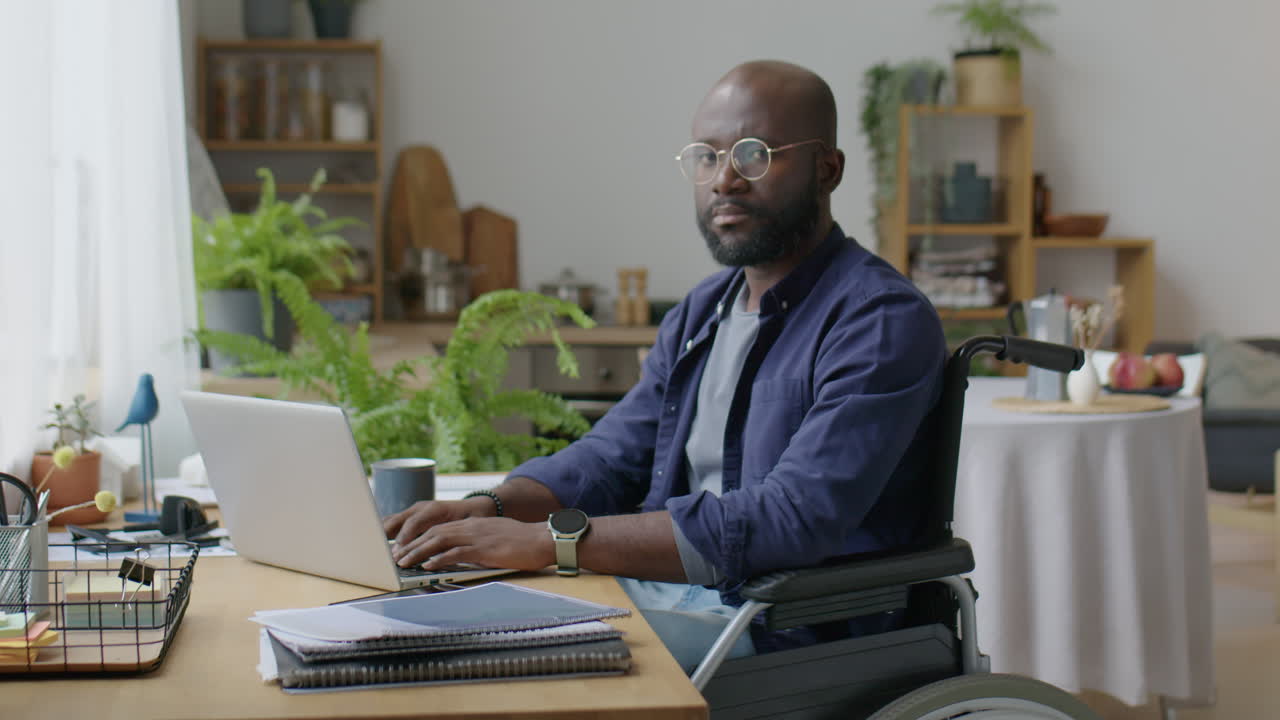Portrait of Black Man in Wheelchair at Home Workplace