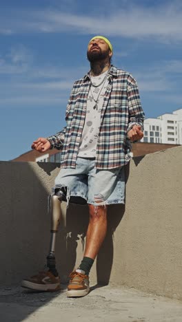 stylish man with prosthetic leg on rooftop