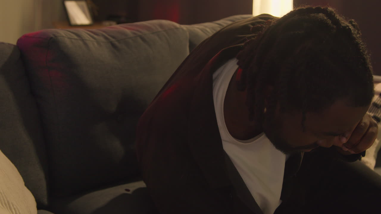 hombre despertando en el sofá después de beber alcohol en la fiesta de la casa sufriendo de resaca hablando en el teléfono móvil 3