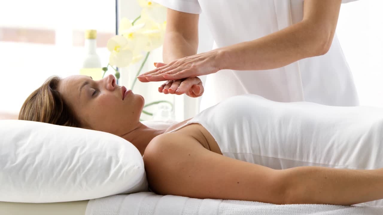 terapeuta poniendo sus manos por encima del paciente