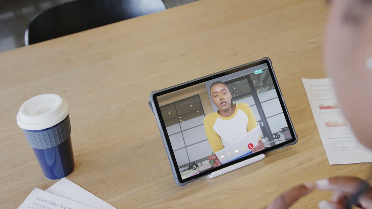 mujer de negocios caucásica en una videollamada con un colega afroamericano en la pantalla