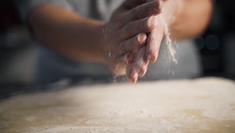 Close-up,-slow-motion-view-of-woman's-hands-wiping-off-flour-after-working-with-pastry-dough