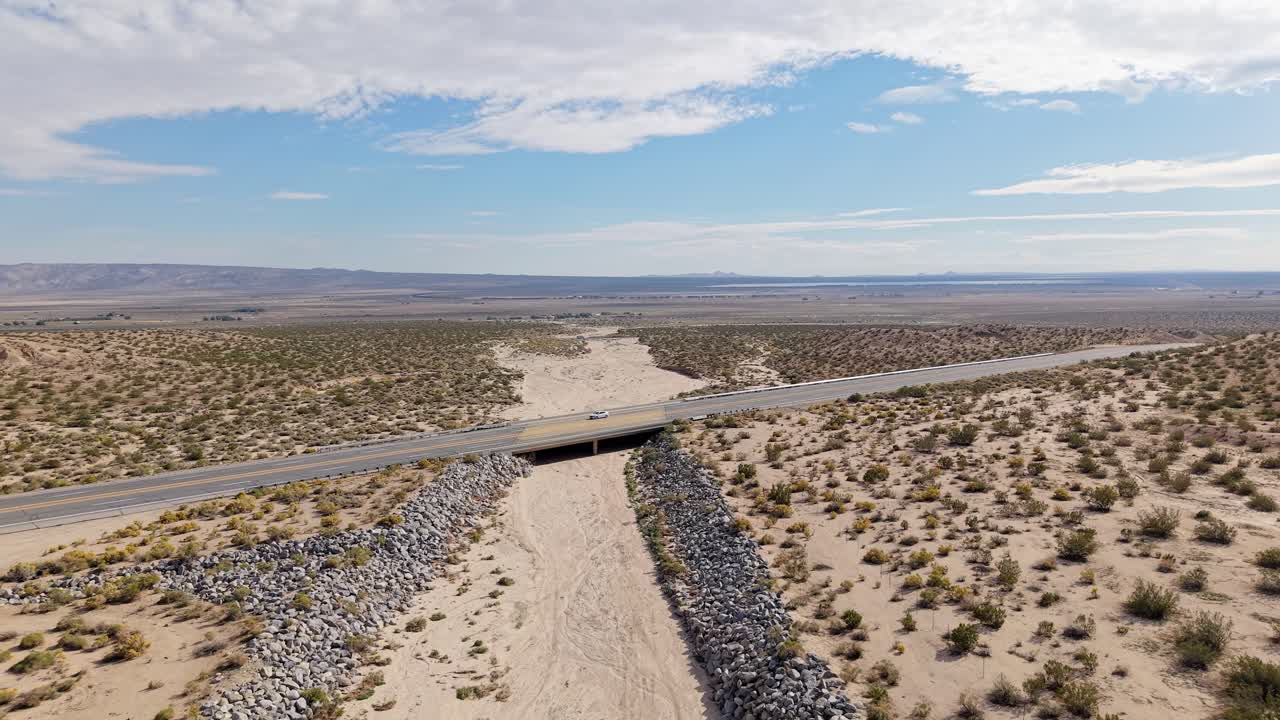 From above, the drone captures the sharp contrast between the canyon’s angular structures and the smooth desert expanse surrounding them