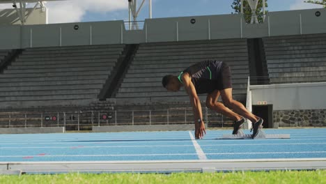 Side-view-of-mixed-race-athlete-preparing-for-race-in-stadium