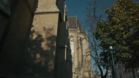 fachada de la iglesia gótica y faro bajo un cielo azul claro en viena