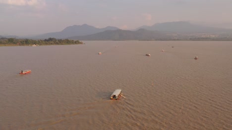 drone: tracking shot of boats at janitizio in patzcuaro lake at the sunset