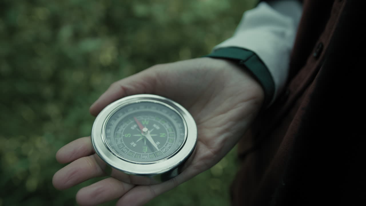 la mano de la mujer encuentra la orientación con una brújula en las montañas