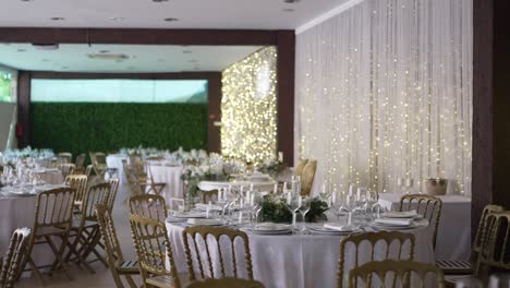 elegant wedding reception setup with golden chairs, round tables, and soft fairy lights