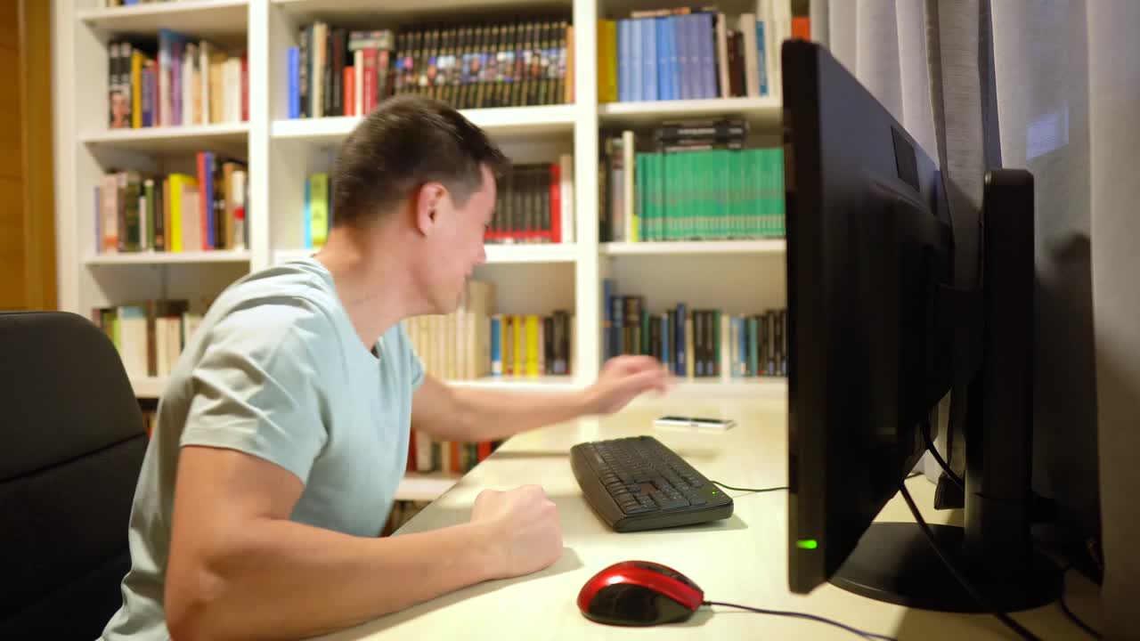 Man Talking on Phone and Reacting at Computer Desk