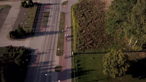 aerial following a group of cyclists riding bikes on goldap town, poland