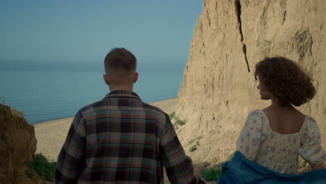 Couple-going-down-coast-to-sandy-beach.-Happy-woman-adoringly-looking-at-man.