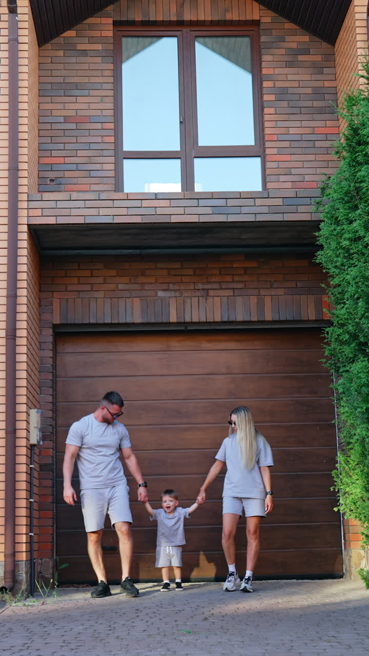 Gezinswandeling voor een moderne woning. Een gezin wandelt samen buiten hun eigentijdse huis, genietend van quality time op een zonnige dag.