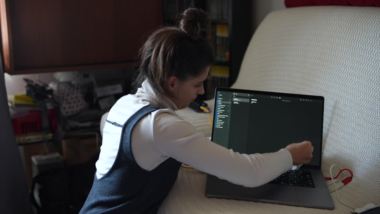 mujer limpiando su portátil en casa