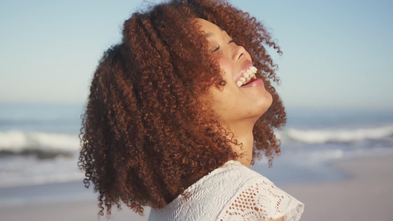 retrato de una mujer afroamericana riendo en la playa
