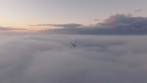 drone shot of a windturbine in foggy conditions