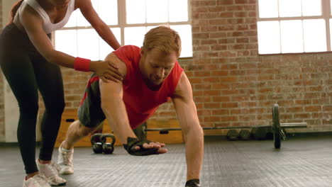 fit man going plank exercises with trainer