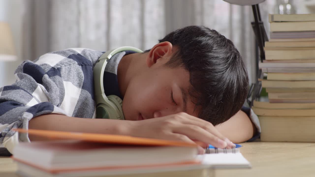 지친 학생 이 책상 에서 잠을 자고 있다