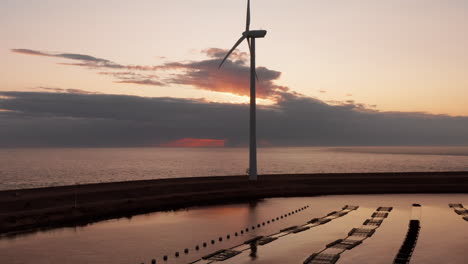 windturbines and aquaculture during sunset on the island neeltje jans, the netherlands