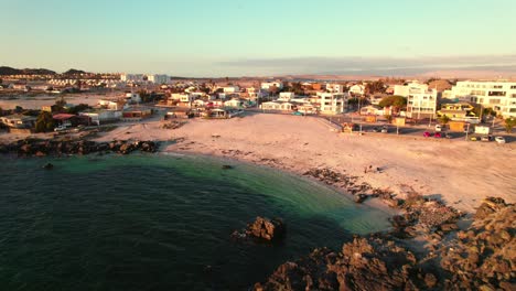 Vista-Aérea-De-Dolly-En-La-Playa-De-Bahía-Inglesa-En-La-Región-De-Coquimbo-Con-Colores-Naranjas-Y-Aguas-Cristalinas-Al-Atardecer.