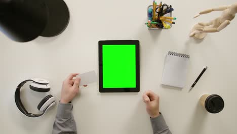 a finger touching a green screen of the tablet computer