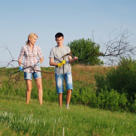 A-Woman-With-Her-Teenage-Son-Is-Cleaning-Up-The-Garbage-In-The-Meadow