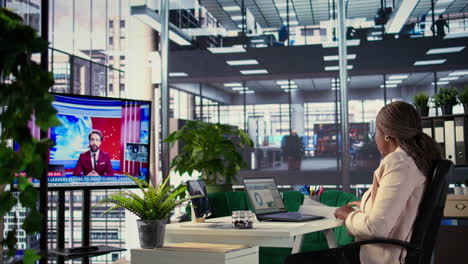 business woman working in modern office, watching news report