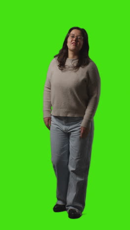 Vertical-Video-Full-Length-Portrait-Shot-Of-Smiling-Casually-Dressed-Young-Woman-Standing-Against-Green-Screen-3