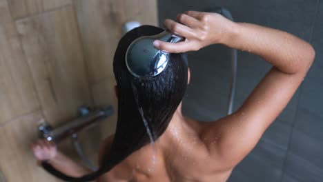 mujer lavándose el cabello en la ducha