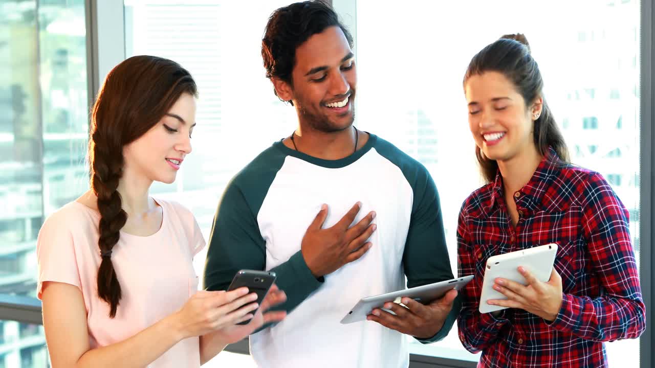 grupo de ejecutivos discutiendo sobre dispositivos electrónicos