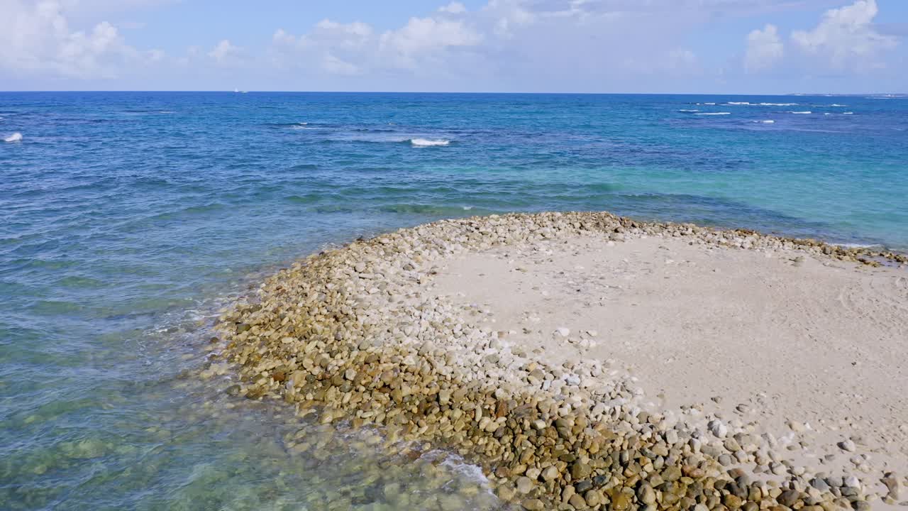화창한 날 플라야 도라다(playa dorada)의 모래와 푸른 색 카리브 바다가 있는 바위 해안의 공중 전망 - 지평선을 향해 앞으로 비행