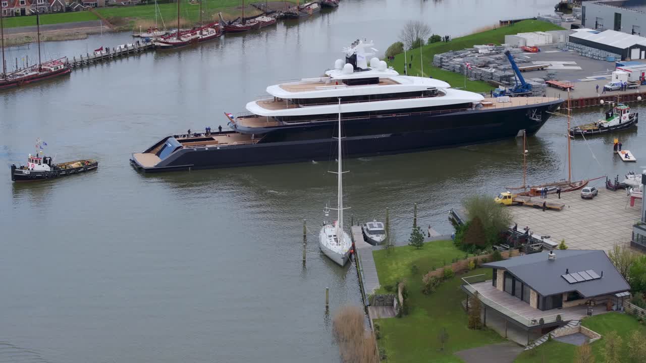 Darsene industriali con super yacht e rimorchiatore a Makkum, Paesi Bassi