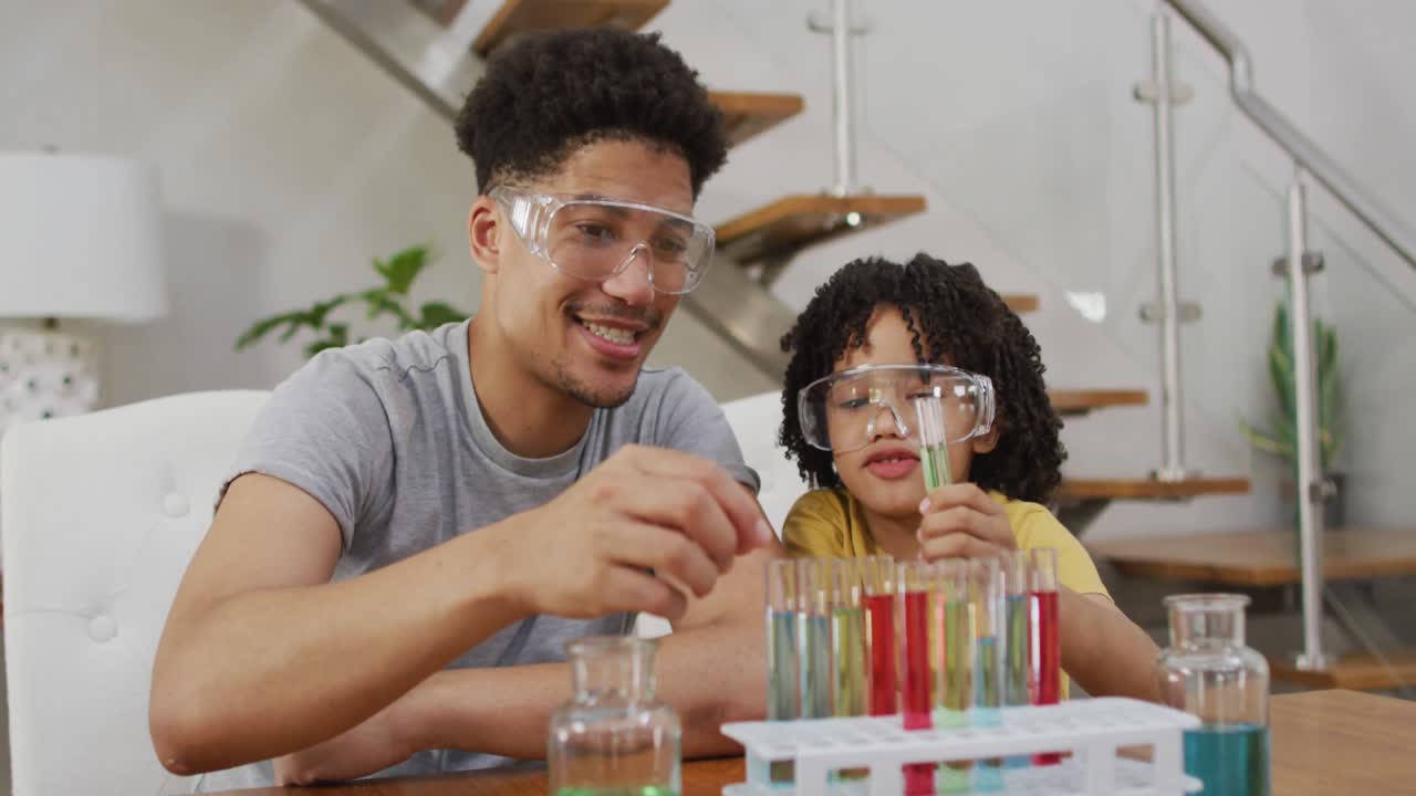 feliz hombre biracial y su hijo haciendo experimentos de química