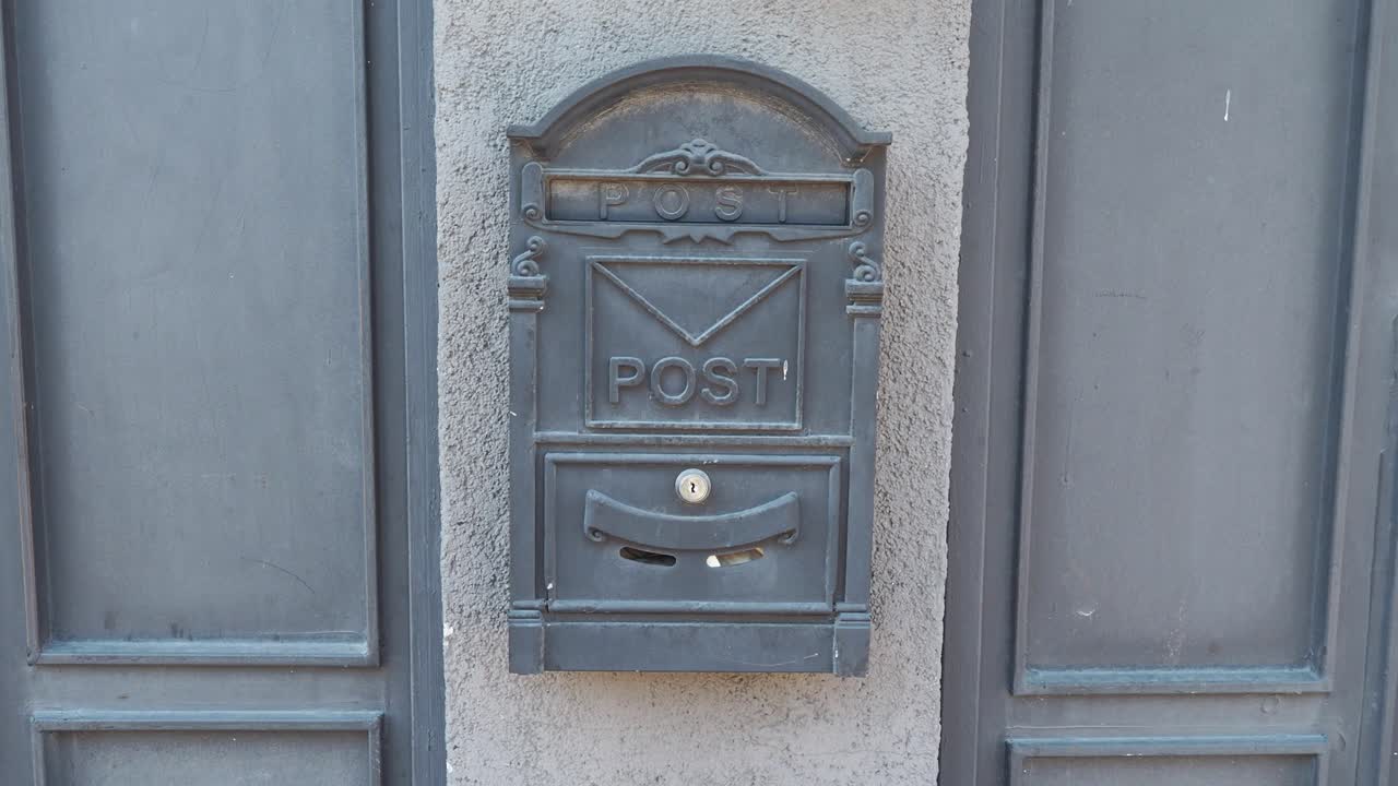 черный почтовый ящик с металлической дверью на стене