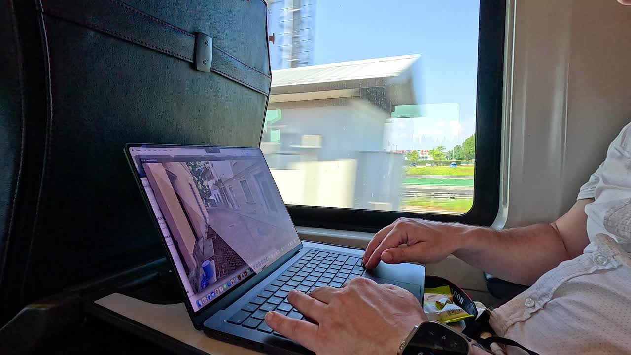 persona que usa una computadora portátil en un tren en milán