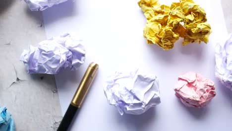 crumpled paper and pens on a desk