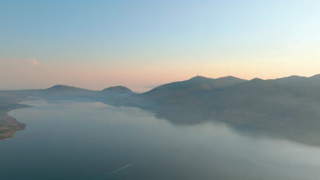 aerial view of mountains and lake at sunrise/sunset