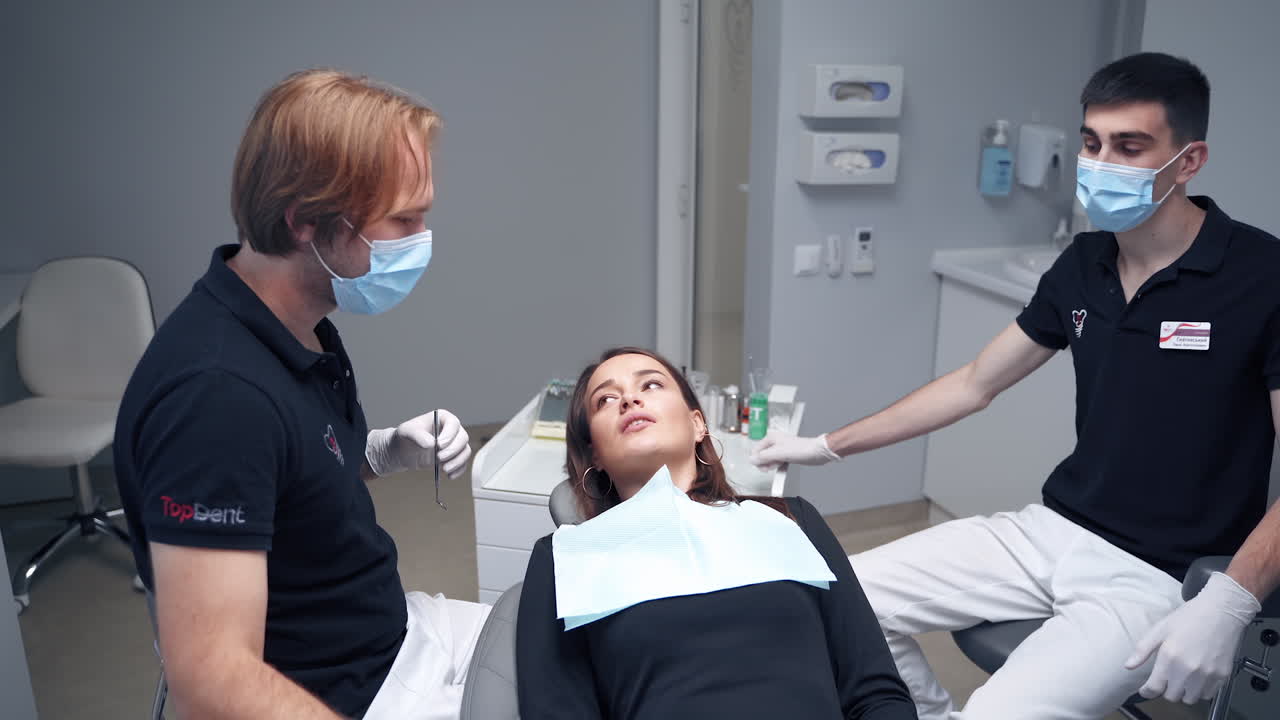Professional stomatologist at work. Dentist treating teeth to woman patient in clinic