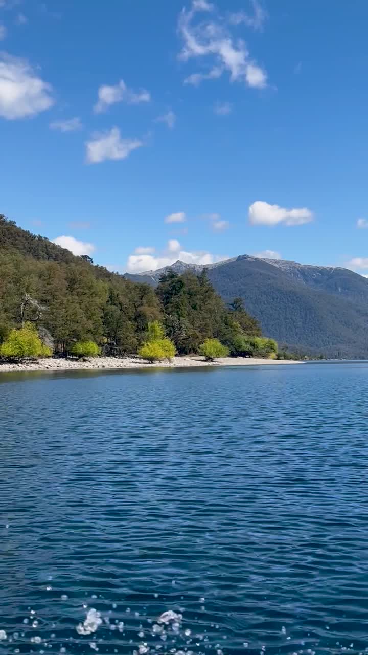 Lago Lacar Quila Quina in Argentina, clear blue water surrounded by lush green mountains